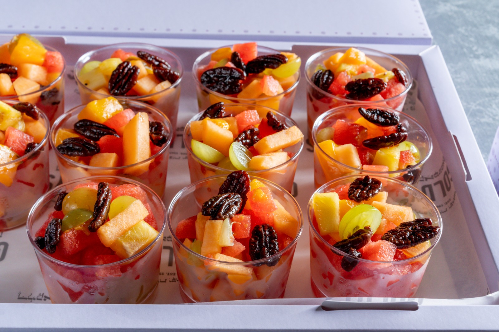 A tray of fruits & pecans salad cups